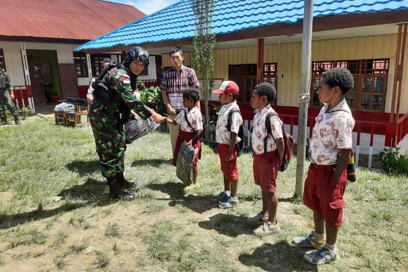 Satgas Pamtas Yonif Raider 142/KJ Bagikan Tas Sekolah Untuk Anak SD Negeri Karubaga. / FOTO : PEN SATGAS YONIF R 142