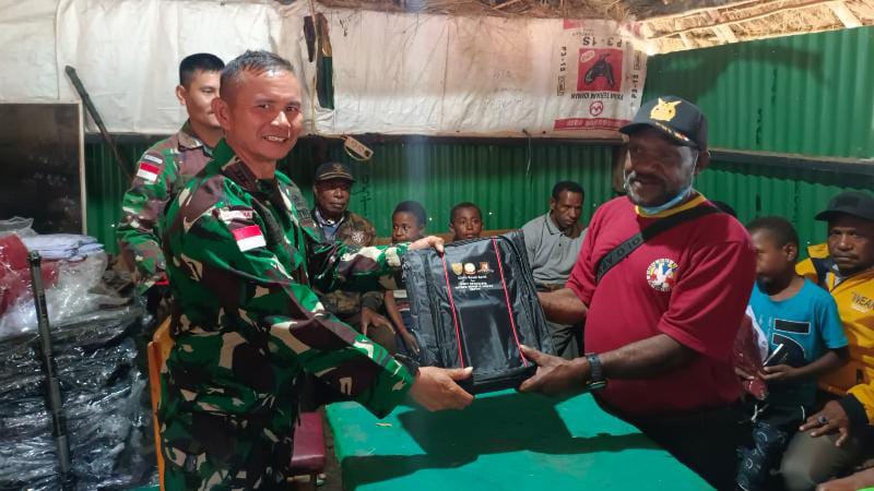 Danpos Bolakme Kapten Inf Oslan Purba SERAHKAN bantuan peralatan sekolah, Al-kitab dan bibit pinang untuk 12 kampung. FOTO : PEN SATGAS YONIF 142